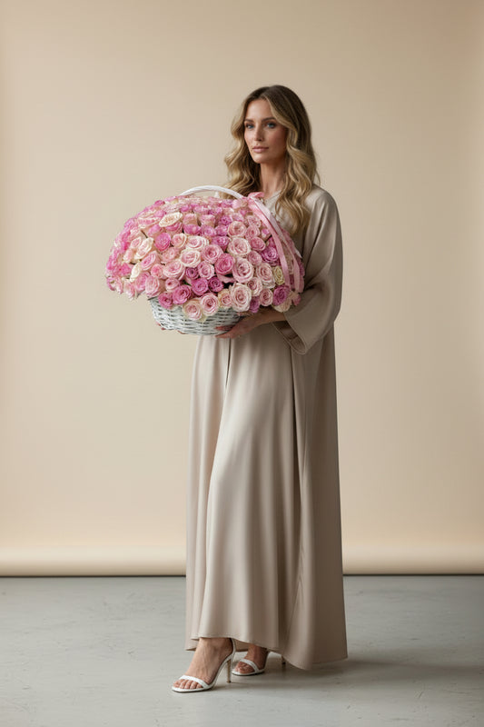Woman holding a large bouquet of pink flowers against a beige background