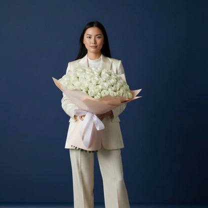 Woman holding a bouquet of white flowers against a dark blue background