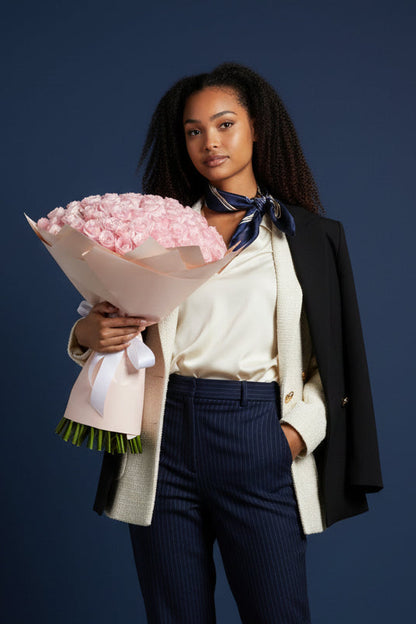 Woman holding a bouquet of pink flowers against a dark blue background