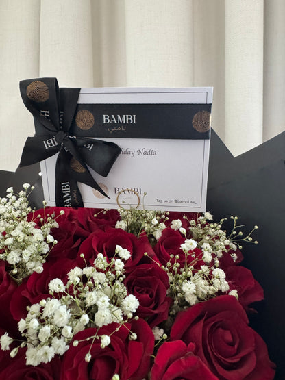 Bouquet of red roses with a black ribbon and gift card on a white background