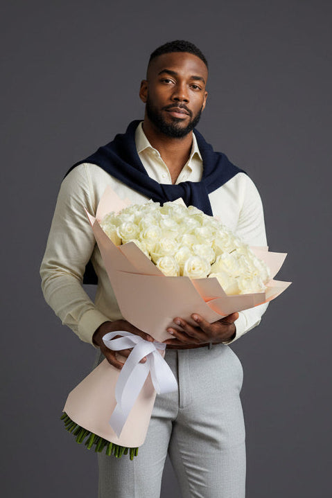 Man holding a bouquet of flowers against a gray background