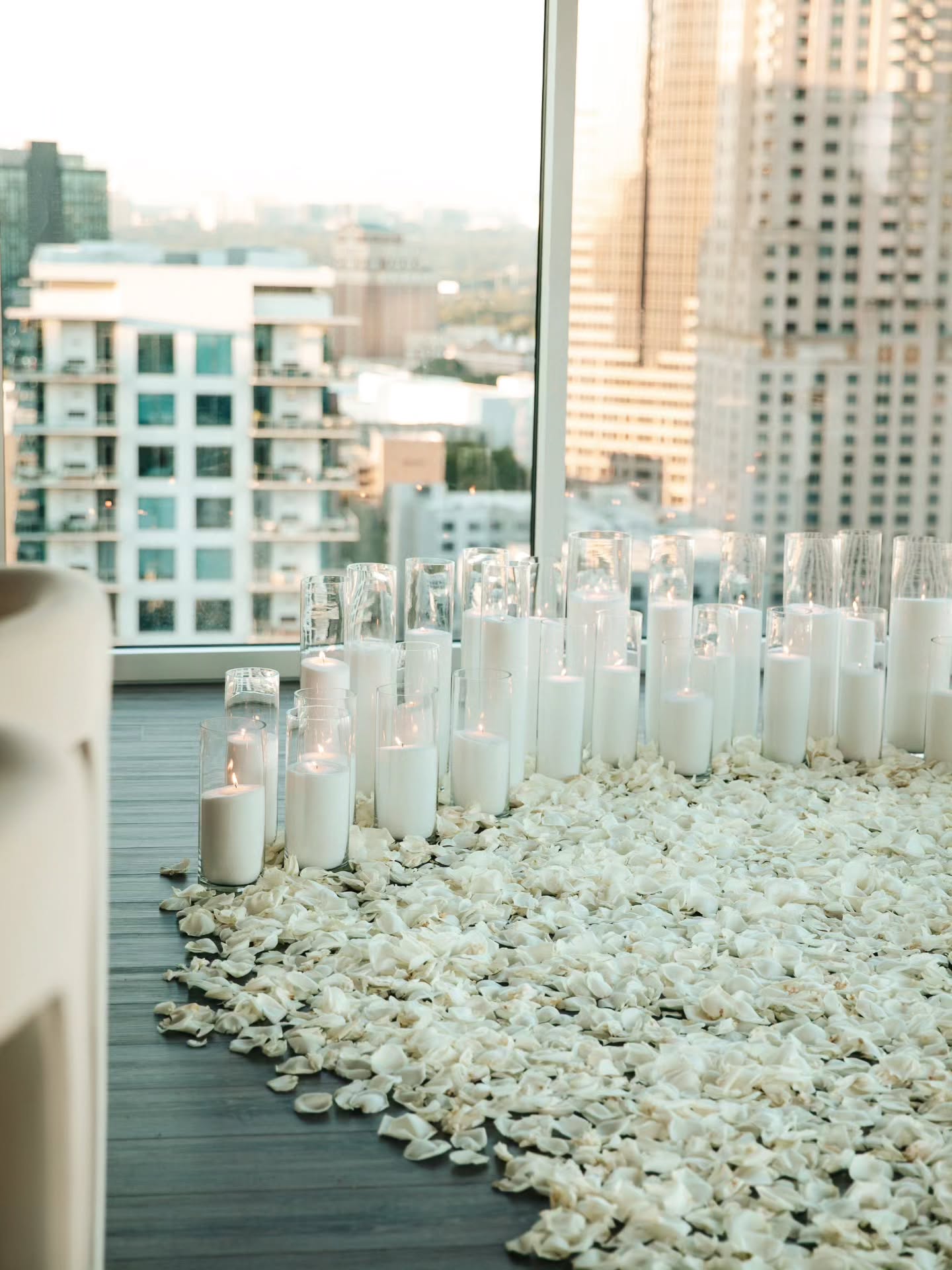 Candles and pebbles on a rooftop with cityscape in the background