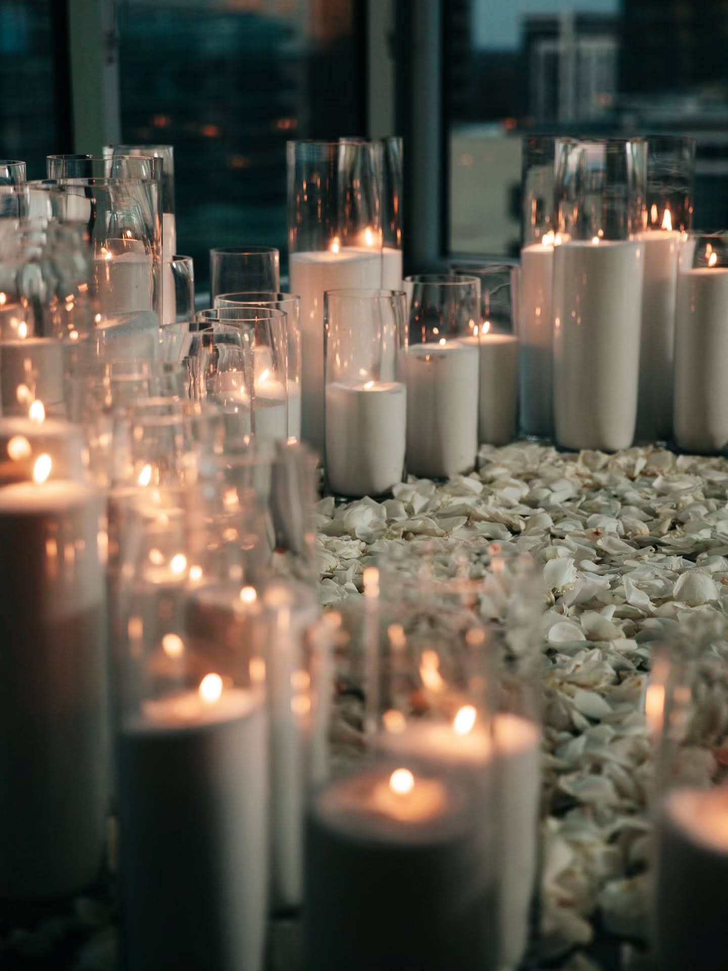 Candles in glass holders on a pebble surface with blurred background