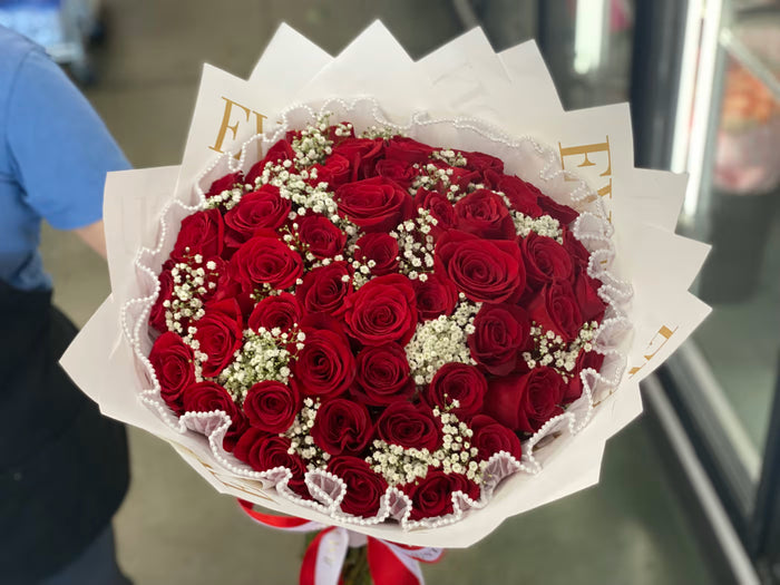 Bouquet of red roses with white accents on a blurred background