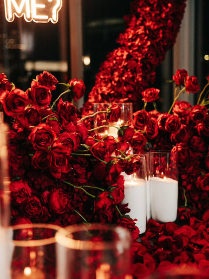 Decorative setup with red roses and candles in a dark setting