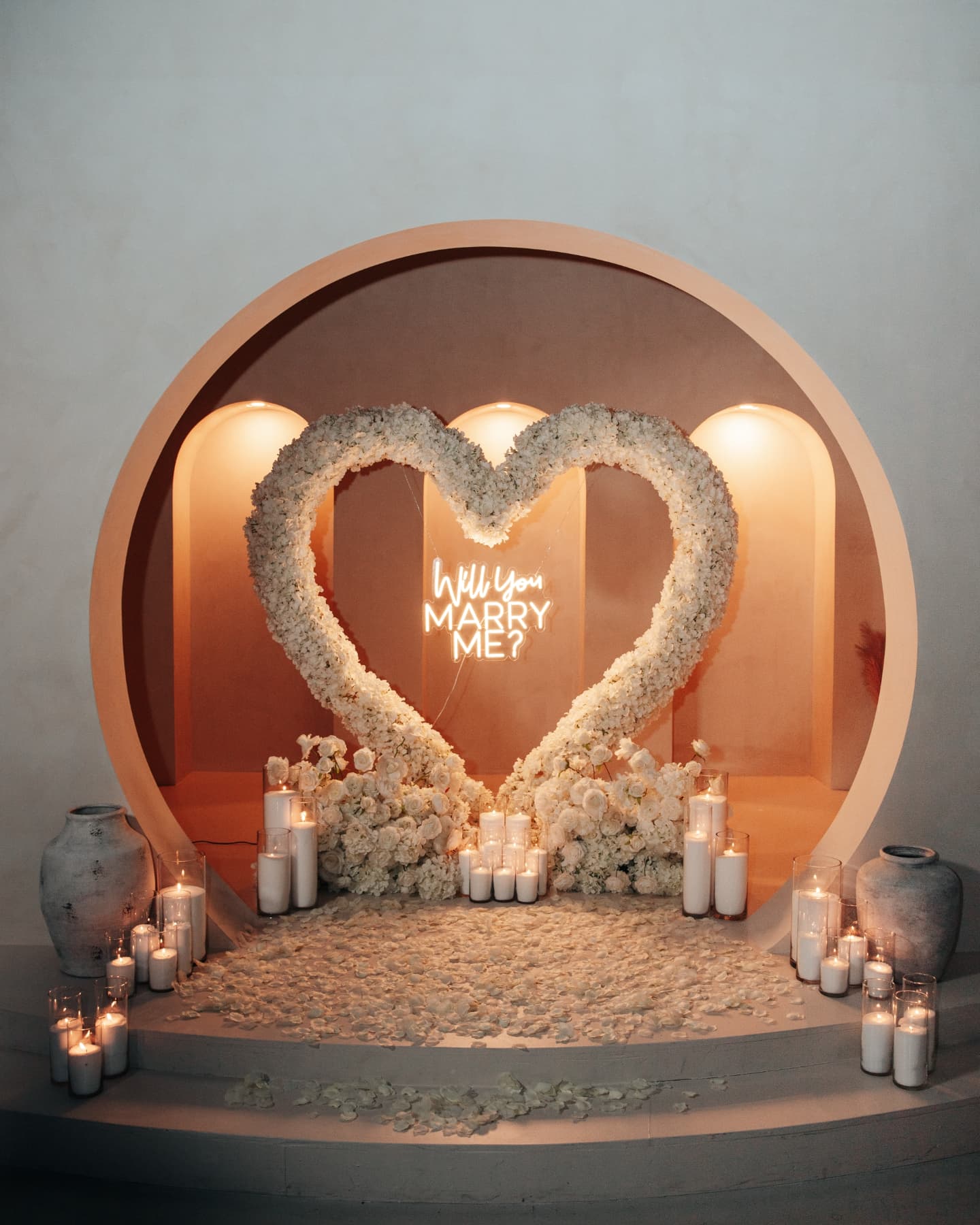 Heart-shaped floral arrangement with candles in a decorative setting