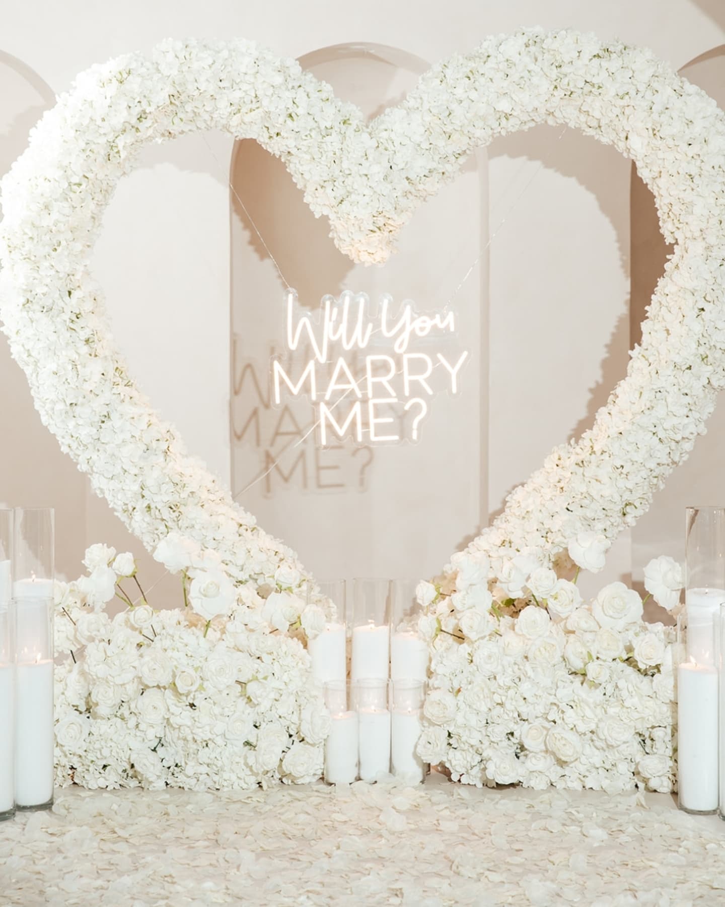 Floral heart arch with 'Will you marry me?' proposal in a romantic setting