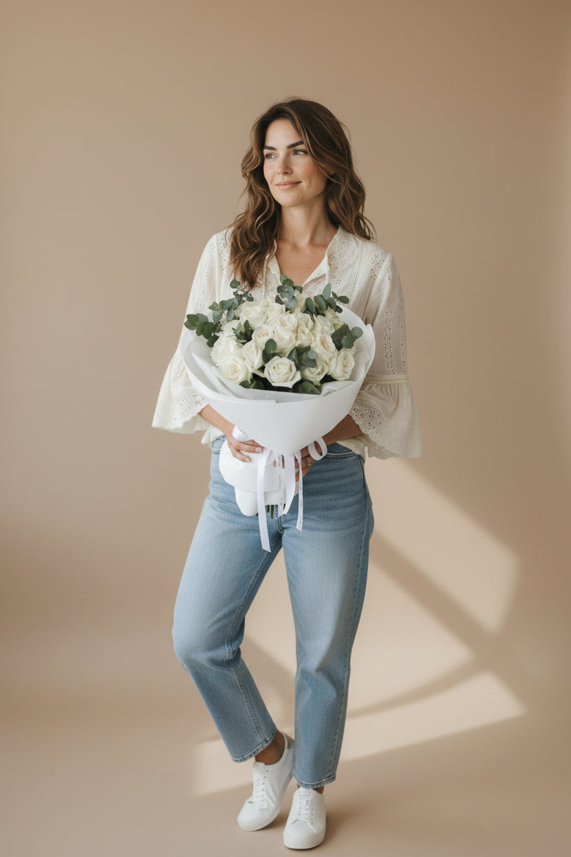 Woman holding a bouquet of flowers against a beige background