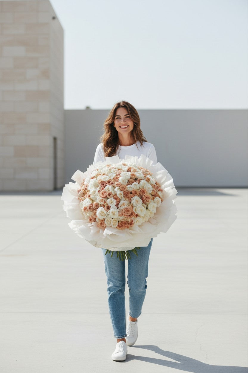 Woman holding a large bouquet of flowers against a light background