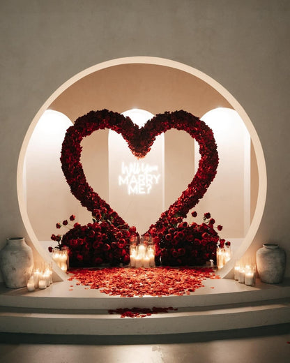 Decorative setup with heart-shaped rose arrangements and candles on a platform.