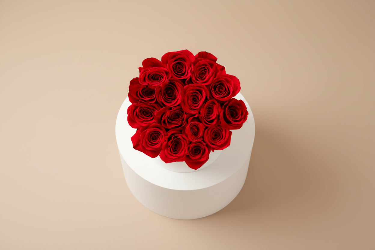 White round container with red roses on a beige background